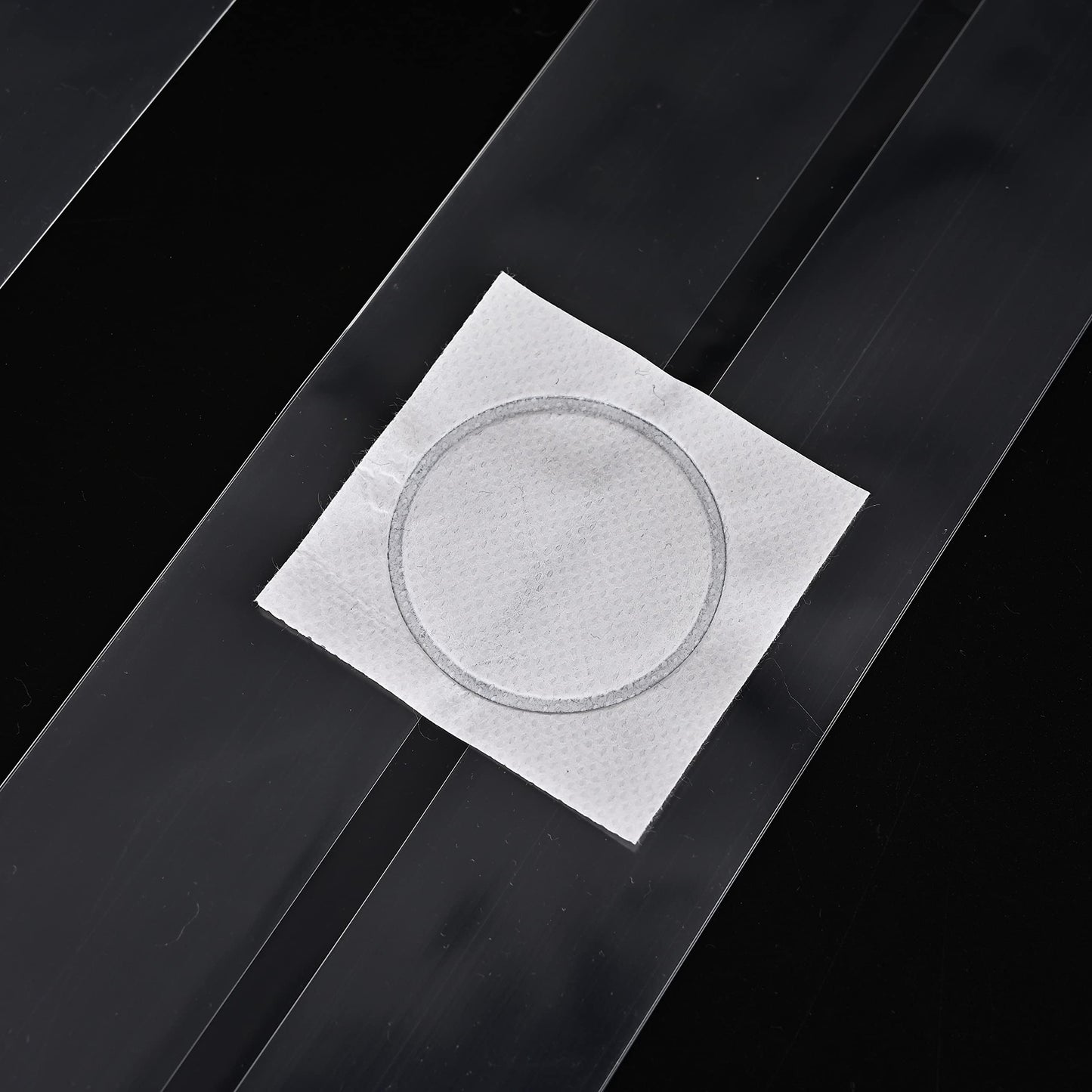 Square white paper with circular cutout on a black background