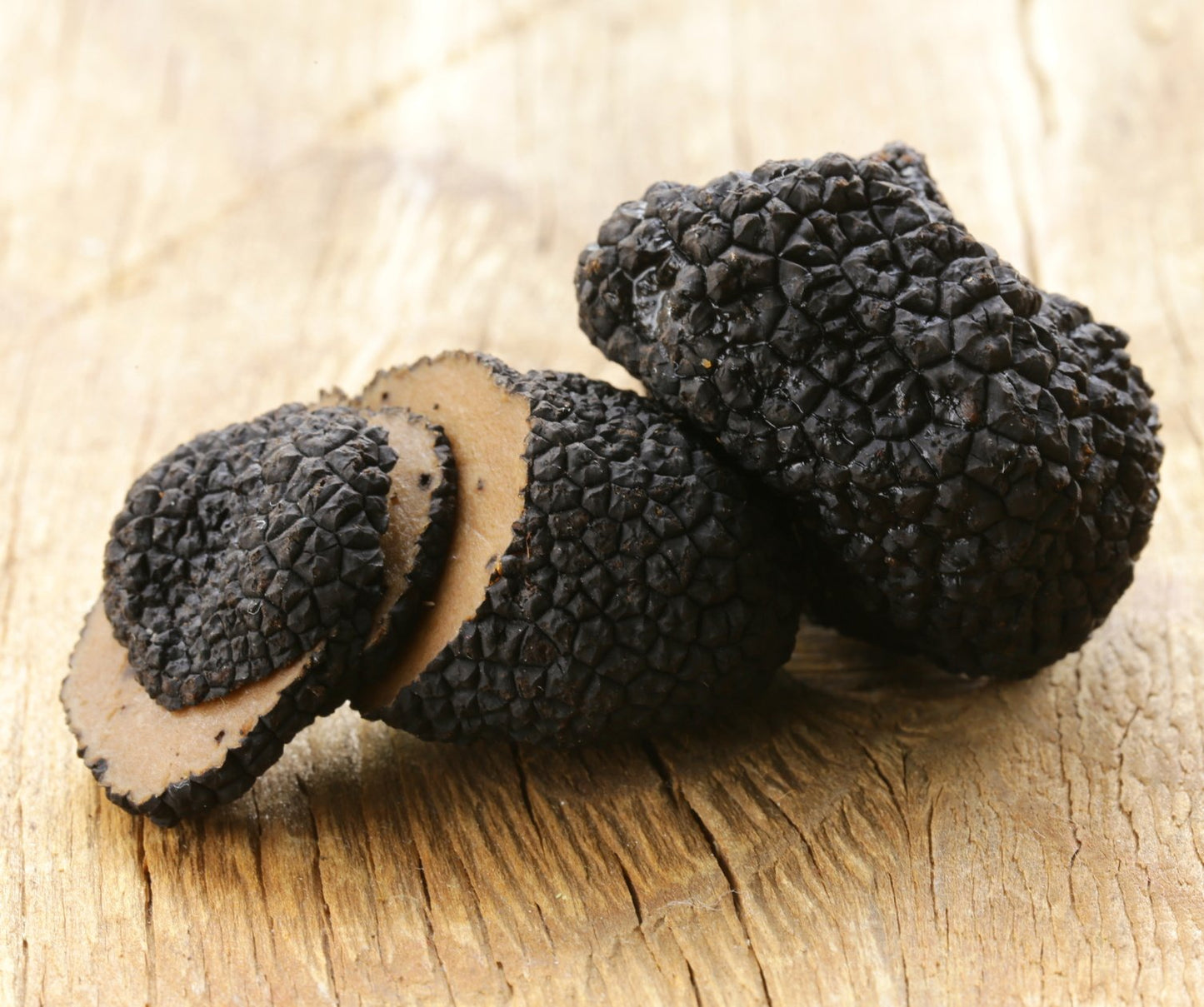 Black truffles on a wooden surface