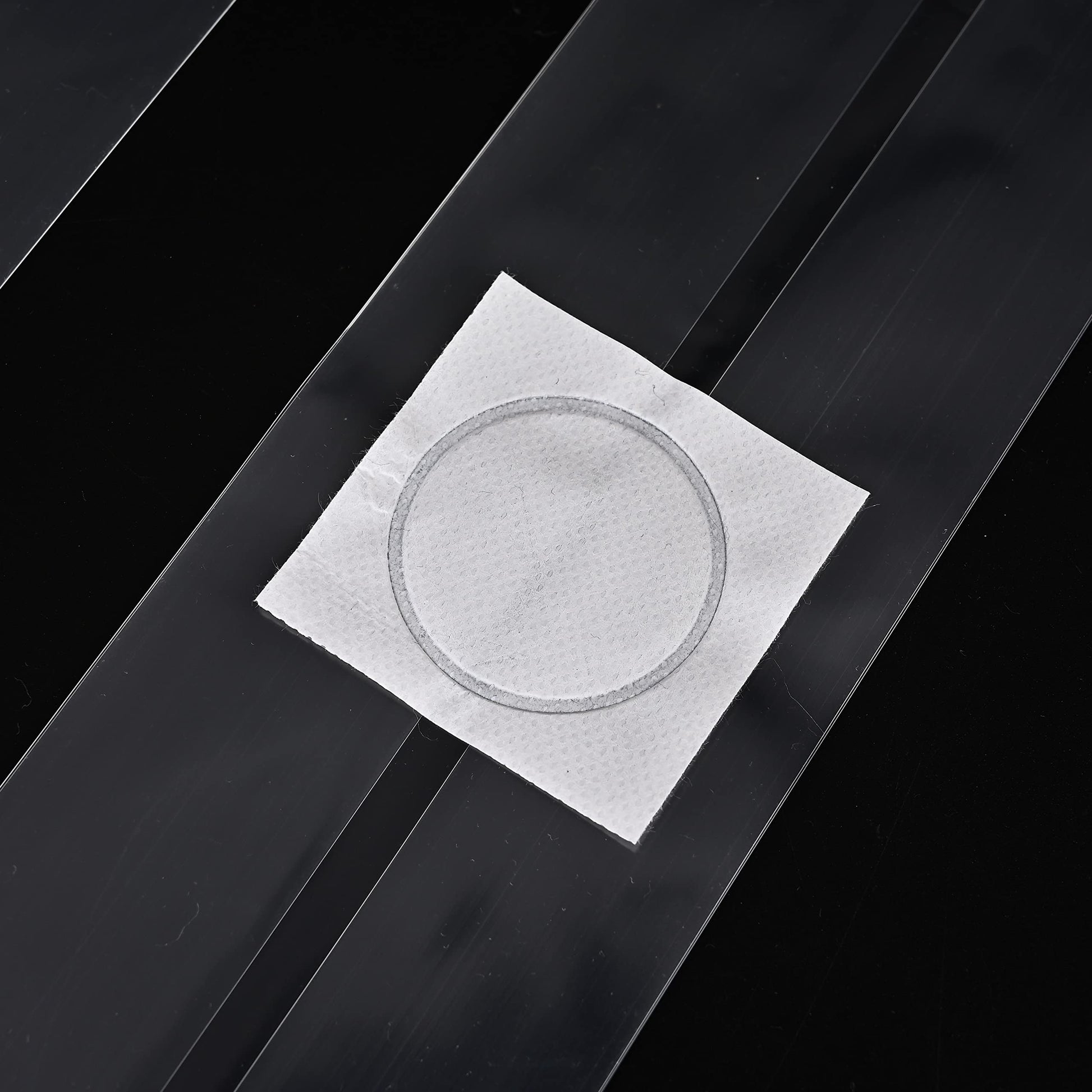 Square white paper with circular cutout on a black background